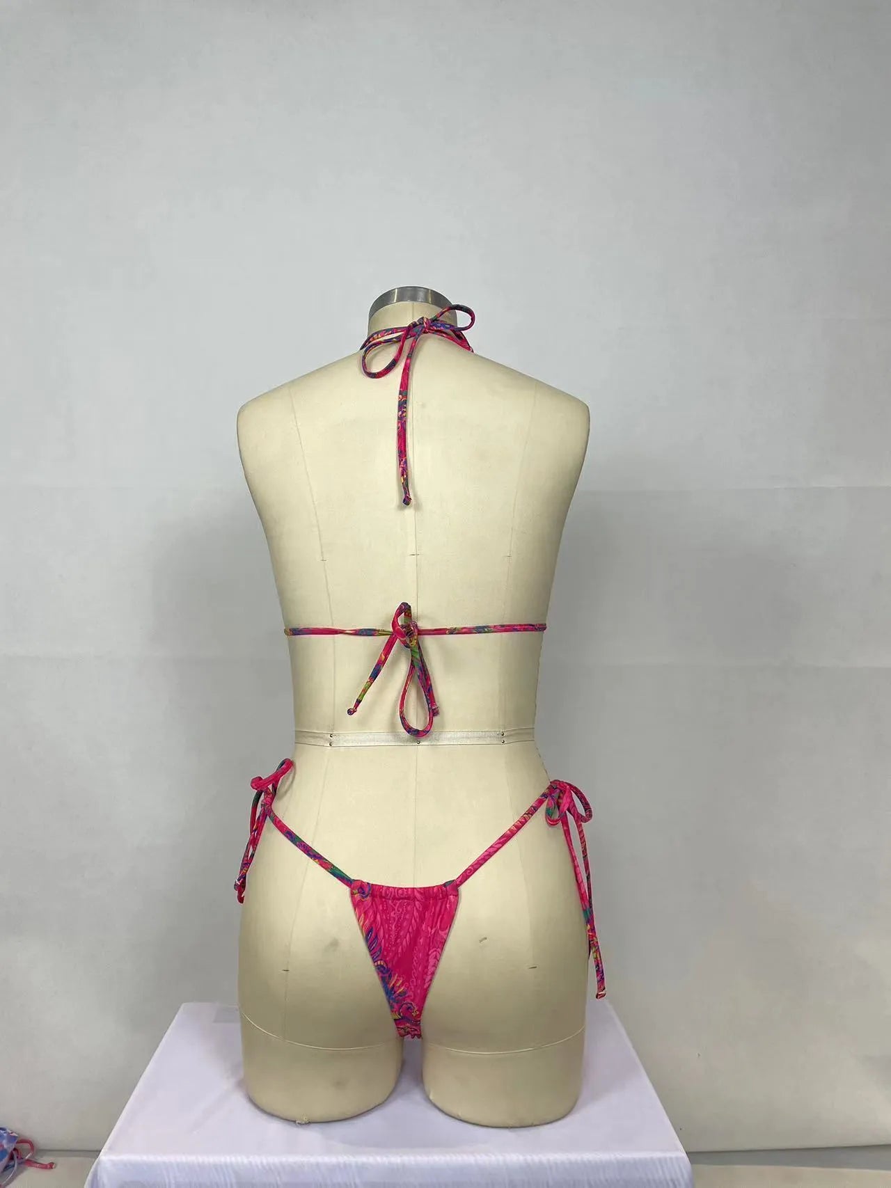 Women's pink printed bikini two-piece set with triangle top and briefs on display
