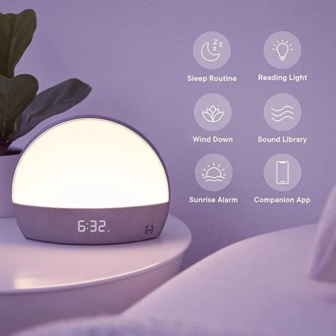 Hatch Restore smart clock in light grey with a night light and white noise machine on a bedside table