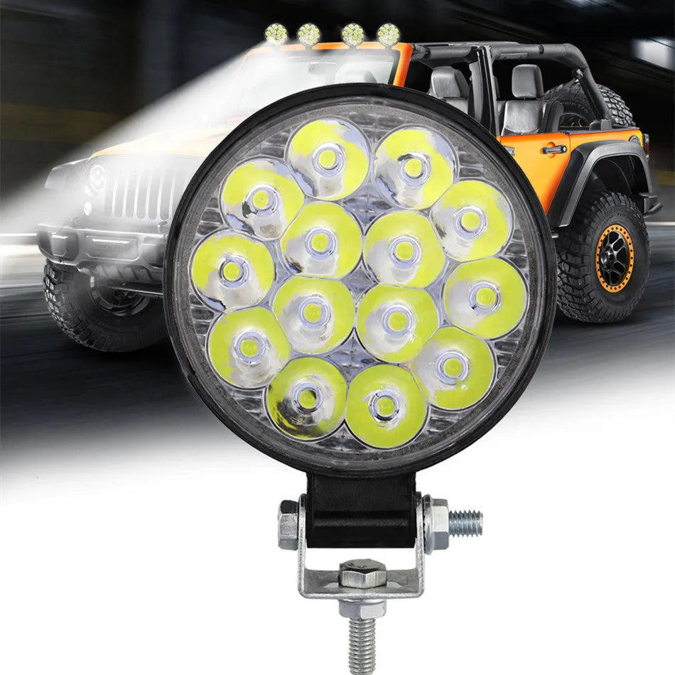 White aluminium LED work light with a round design, suitable for mounting on a vehicle.