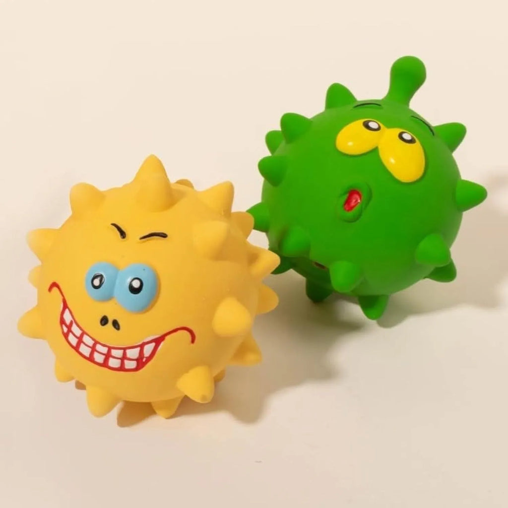 Four colourful natural latex squeaky dog toy balls with cute faces on a blue background.