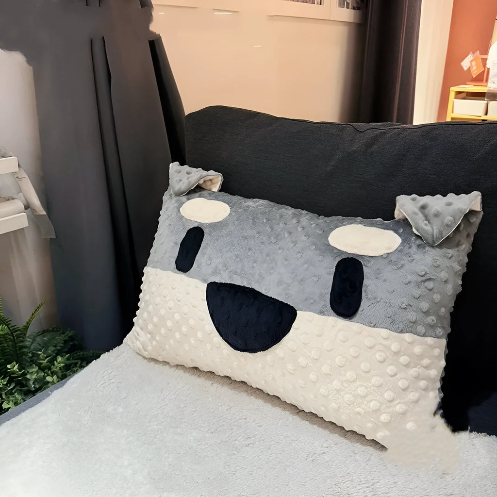 Grey schnauzer and white West Highland puppy decorative throw pillows on a sofa.