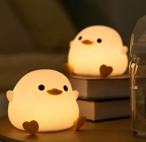 Seagull silicone night light in yellow colour with soft warm glow on bedside table