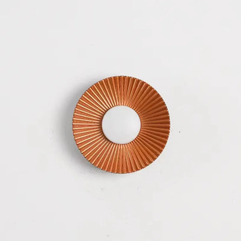 Round wall lamp with aluminium shade in a two-tone white and gold colour combination, mounted on a plain wall.