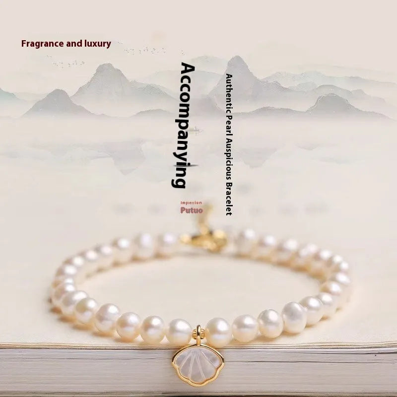 Women's freshwater pearl bracelet with a gold-toned fan charm on a 16cm elastic string.