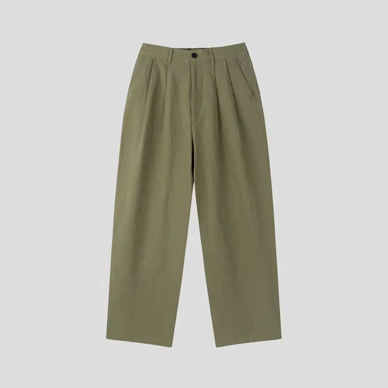 Man wearing apricot-coloured wide-leg cotton linen suit trousers with a pencil leg opening.