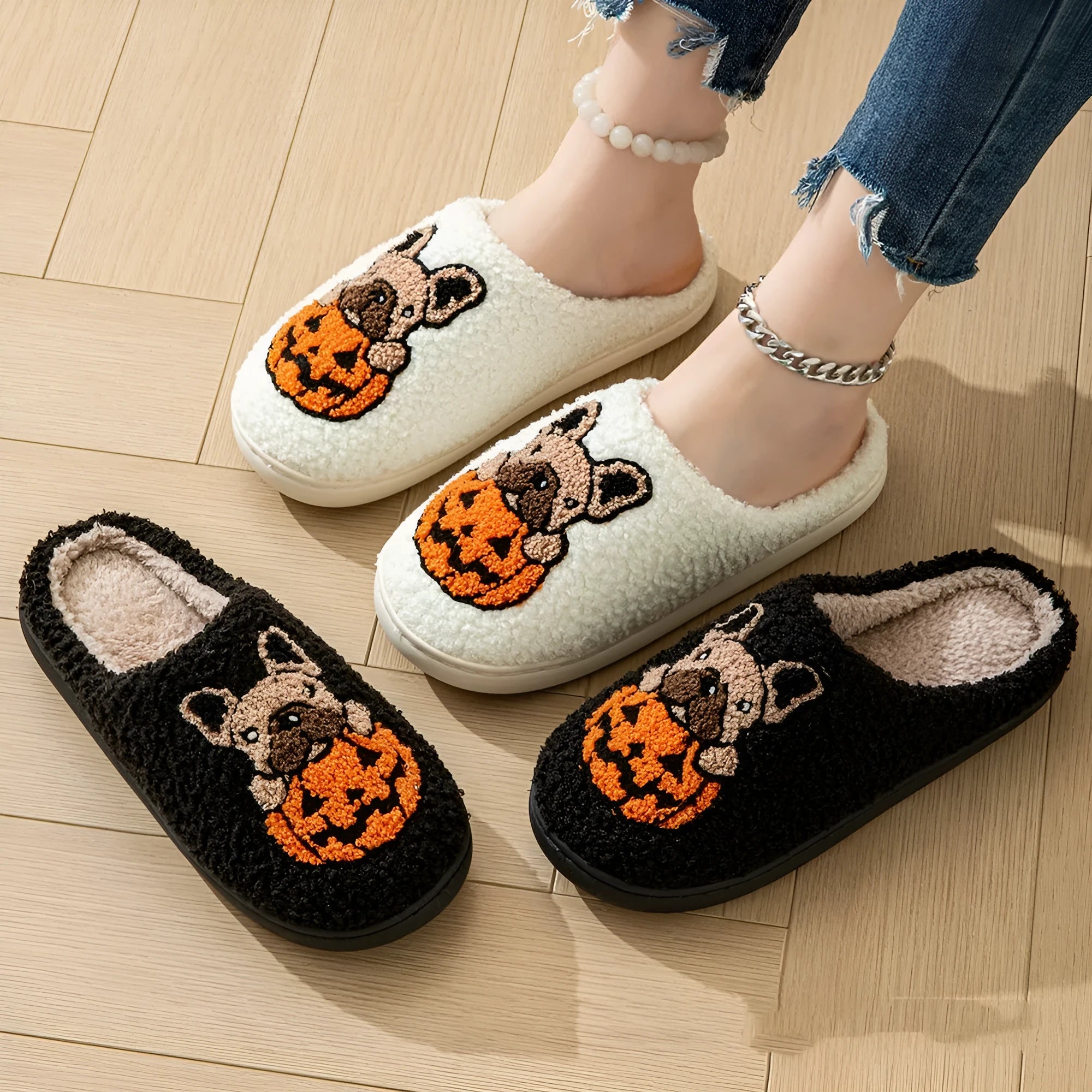 Black and white Halloween slippers with pumpkin design featuring plush uppers and non-slip rubber soles.
