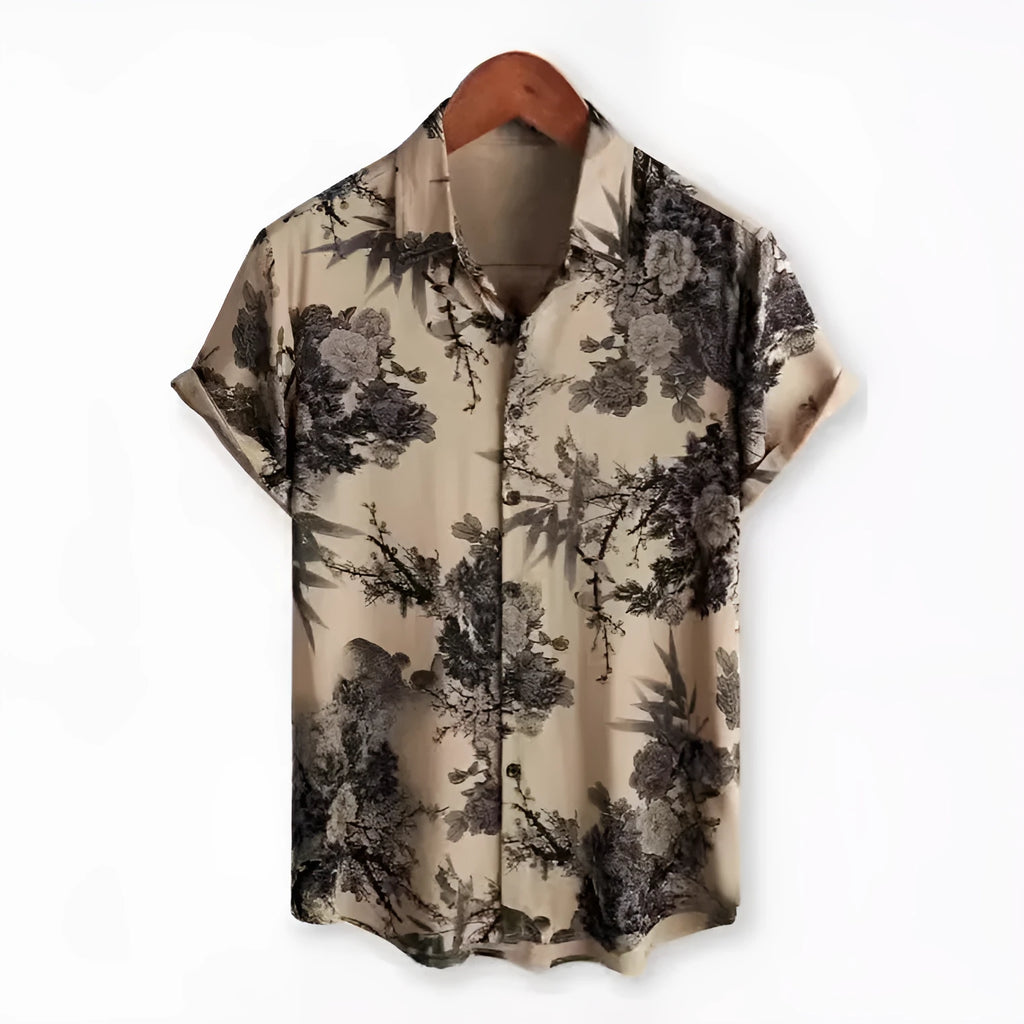 Man wearing a short sleeve Hawaiian shirt with a blue and white floral digital print and a lapel collar.
