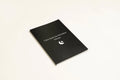 Black cover dream journal notebook with ruled pages open on a desk.