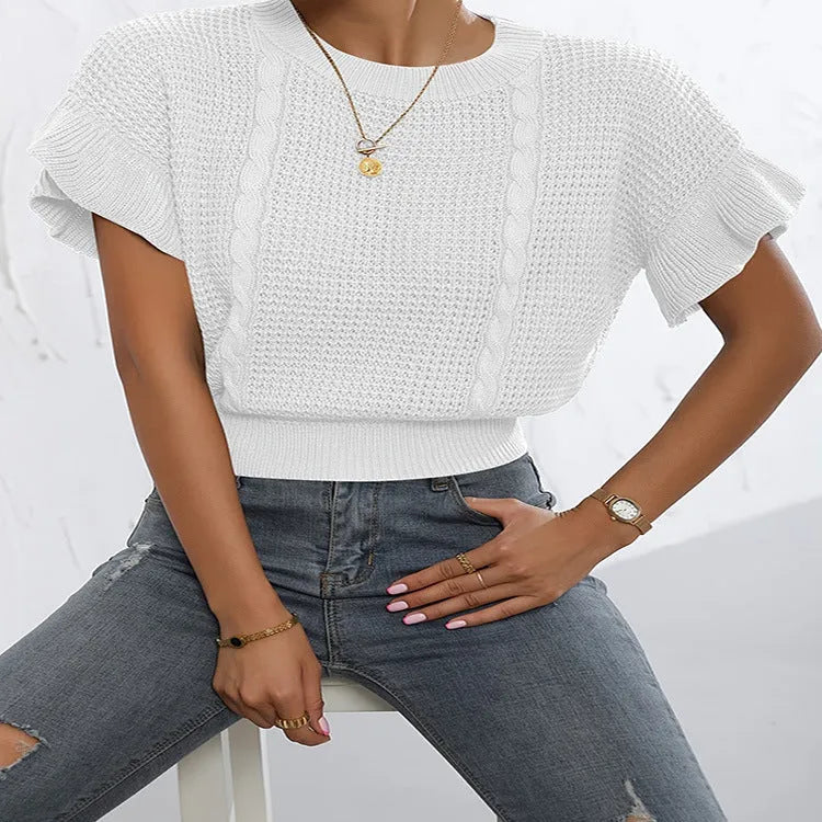 Loose fit knitted pullover sweater with twisted string pattern and ruffled short sleeves on a hanger.