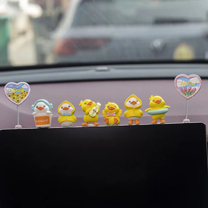 Six yellow PVC duckling car decorations with Hello sign on car dashboard