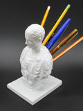 White synthetic resin character model pen holder on a desk.