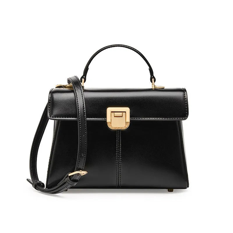Women's black leather shoulder bag with vachette clasp showing organised interior compartments