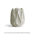 Irregularly shaped art ceramic vase in a low style profile on a wooden surface