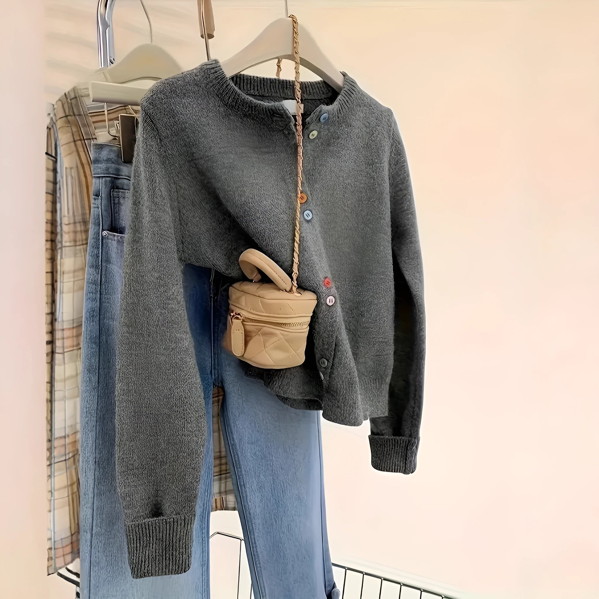 Dark grey women's polyester cardigan with buttons and long sleeves on a hanger