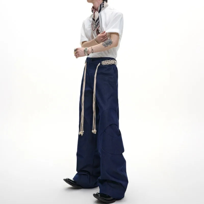 Men's dark blue straight-leg cotton jeans showing 3D cutting, belt stitching, and zipper pocket details.