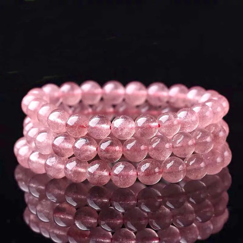 Women's strawberry quartz bracelet with polished beads on elastic string, shown in 6mm, 8mm, and 10mm size options.