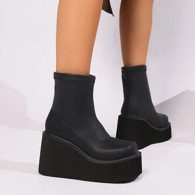 Plus size women's black ankle boots with a wedge heel and waterproof platform sole.