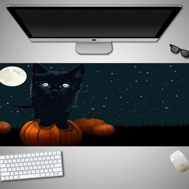 Oversized Halloween-themed rubber cloth mouse pad on a desk, showing non-slip base and large surface area.