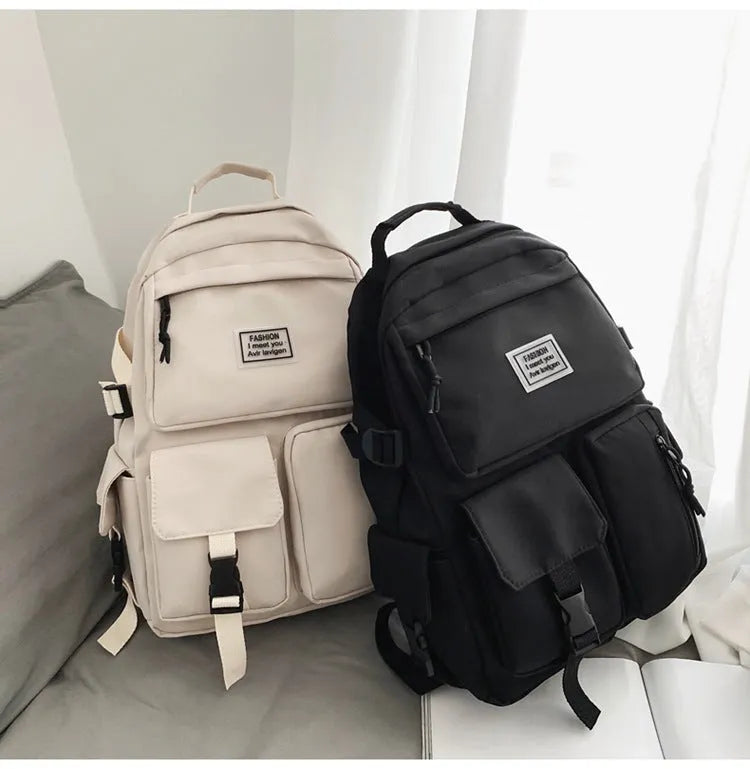 Black nylon student backpack showing front three-dimensional pocket and internal laptop compartment.