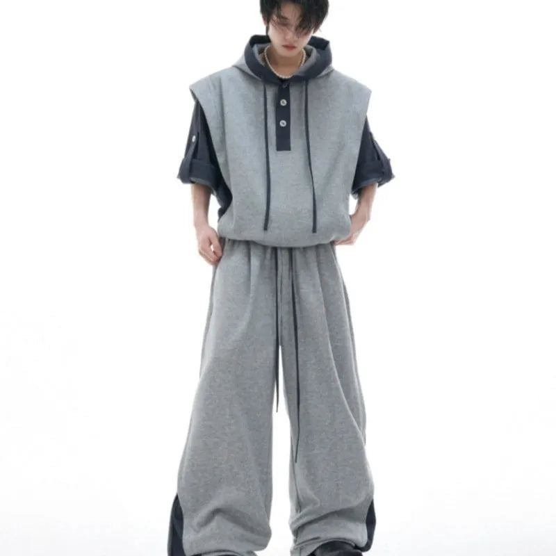 Men's black hooded short sleeve polyester sports suit with textured stitching and matching trousers on a grey background.