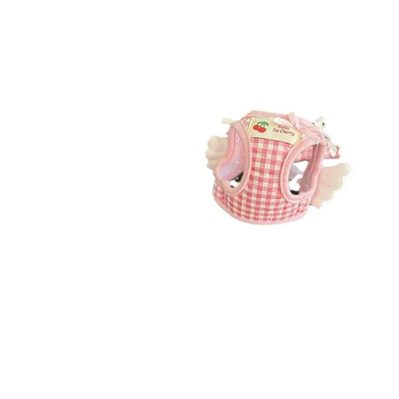 Small dog wearing pink cotton chest and back harness with leash attachment points