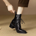 Women's black pointed-toe short tube ankle boots with a low block heel on a neutral background.