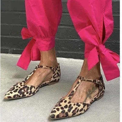 Women's leopard print pointed toe pumps with a low chunky heel and a cross shoulder strap.