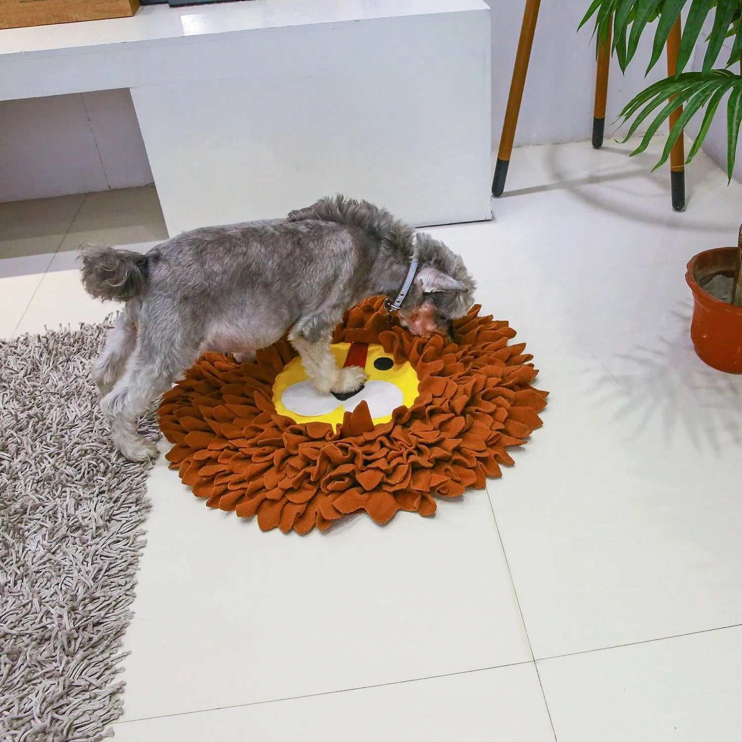 Brown lion-pattern snuffle mat for dogs and cats on a floor, showing plush hiding sections.