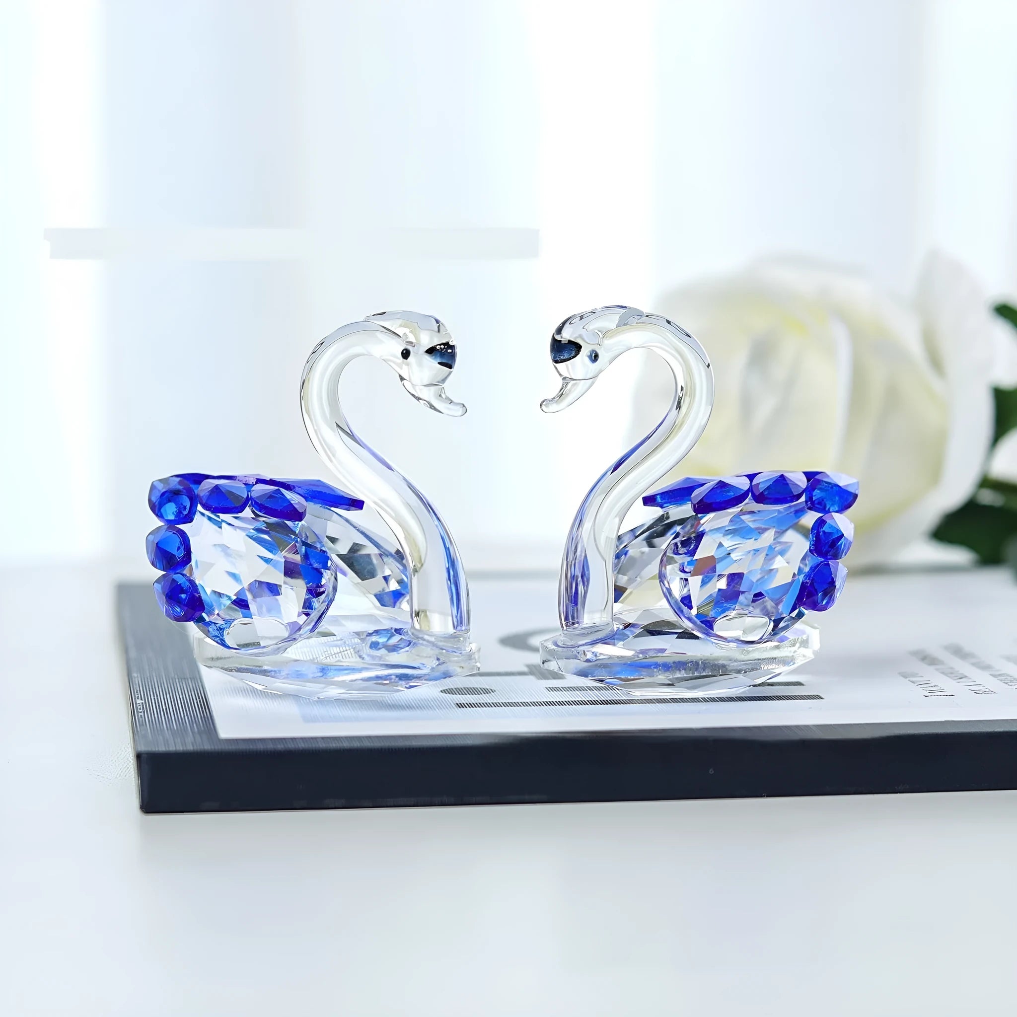 Modern white crystal swan decoration on a desk, available in red, blue, pink, and purple.