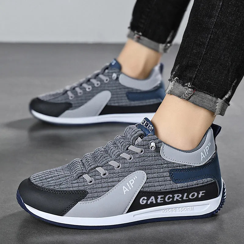 Men's grey mesh running shoes with round toe and lace-up closure on sports surface