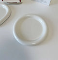 White porcelain plate with bear doodle design, shown as a plant pot tray.