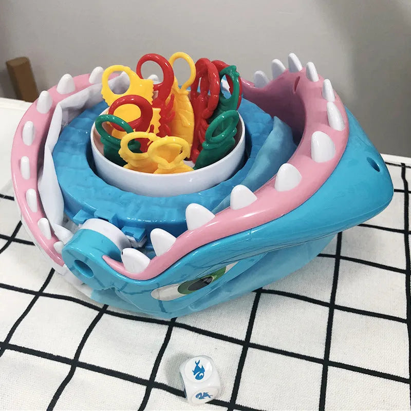 Great white shark tricky toy with small plastic fish inserted in its mouth on a tabletop