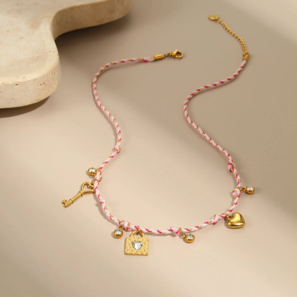 Braided rope chain stainless steel necklace with heart pendant and 18K gold plating on a model.