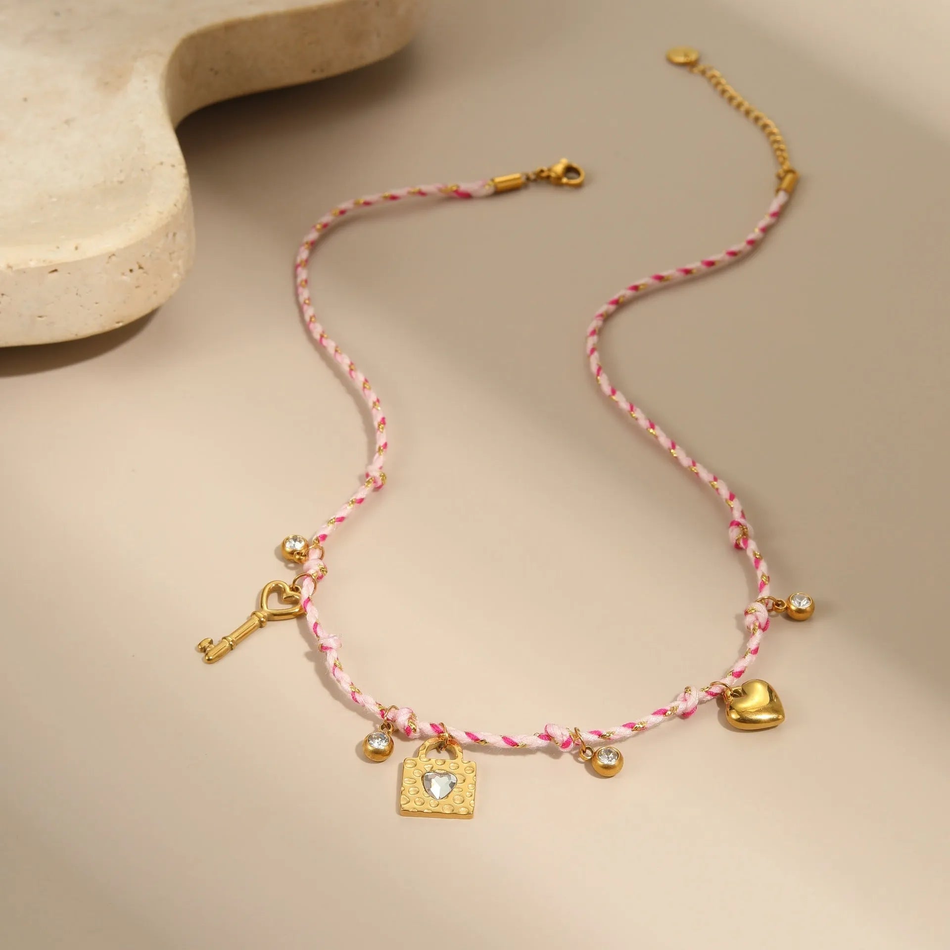 Braided rope chain stainless steel necklace with heart pendant and 18K gold plating on a model.