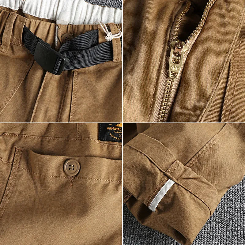 Man wearing mid-waist khaki cotton work trousers with a zipper fly and straight leg cut.