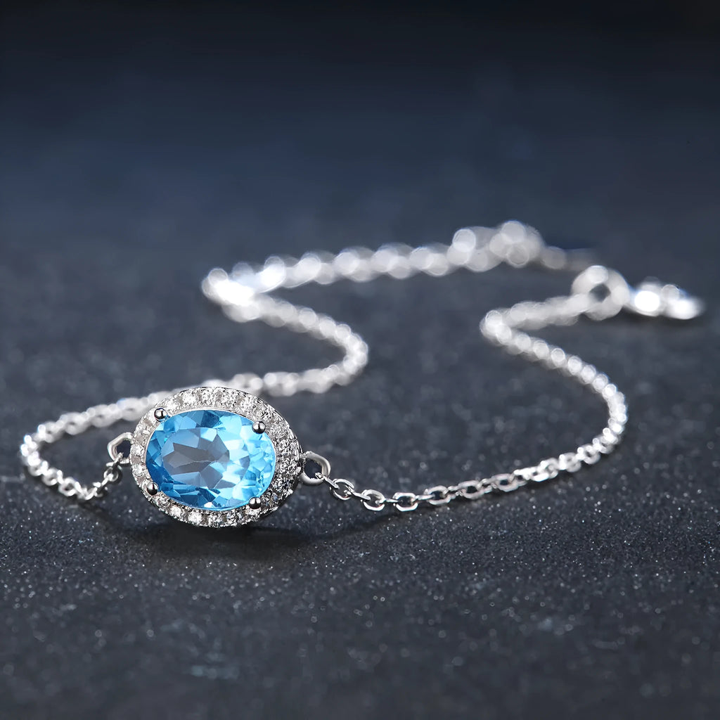 925 sterling silver jewellery set with blue topaz stones showing earrings, ring, pendant, and necklace with chain in geometric design