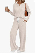 Knitted V-neck striped long coat with long sleeves, pockets, and a lace-up detail on a hanger.