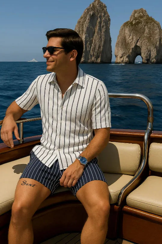 Man wearing a light blue men's beach shirt and matching shorts set on a beach