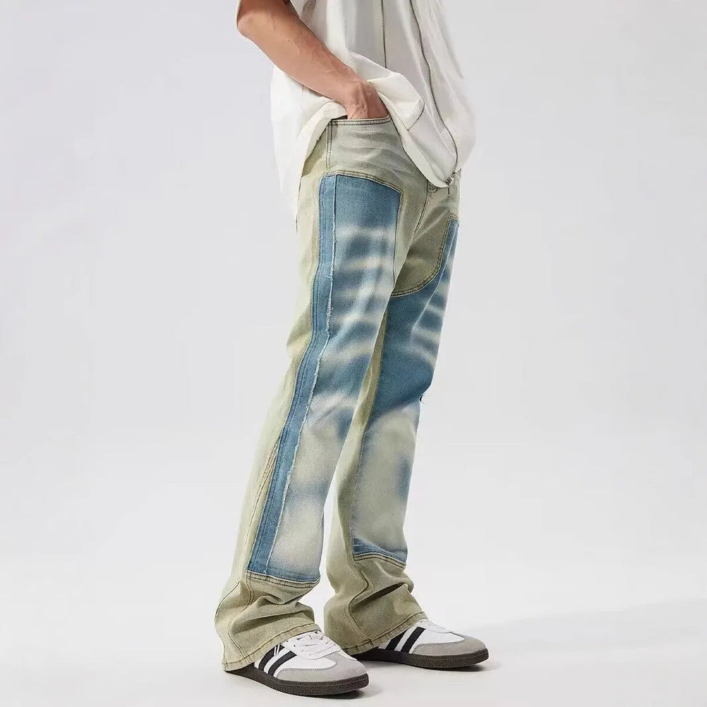 Retro jeans featuring yellow and blue patchwork splash-ink damaged design on non-stretch denim.
