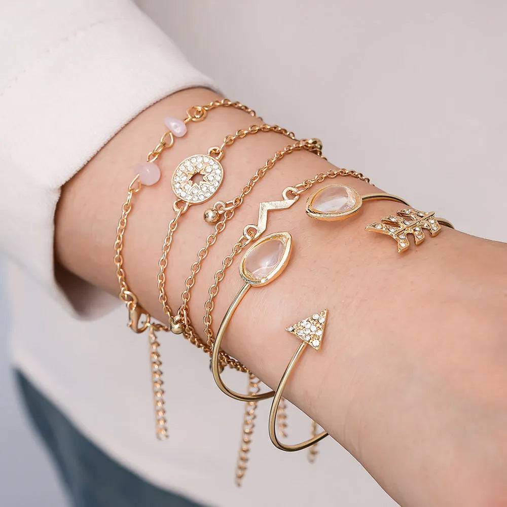 Gold-coloured zinc alloy bracelet set with arrow and V-shaped water droplet design elements