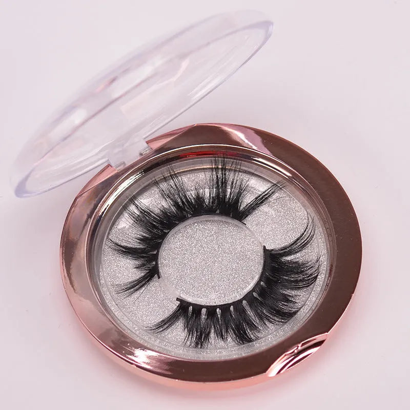 Handmade 5D mink false eyelashes set with brush and storage cap on a white background.