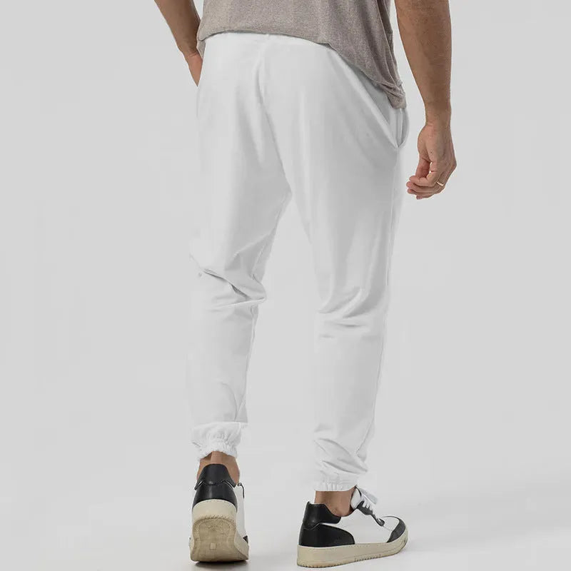 Man wearing grey loose tapered track sweatpants with a casual top