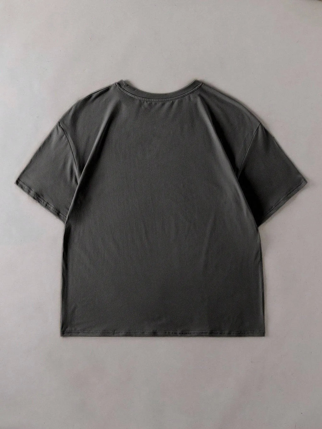 Loose fit cotton t-shirt in black with round neck and short sleeves on a hanger