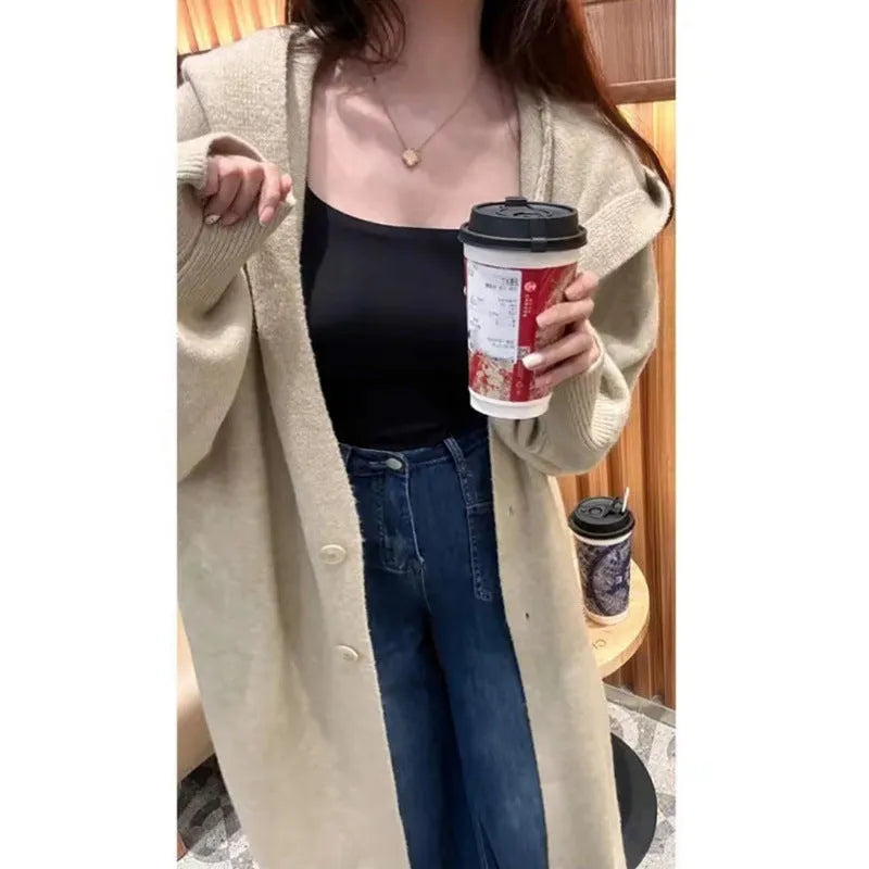 Women's long hooded knitted cardigan in loose fit, shown in oatmeal colour.