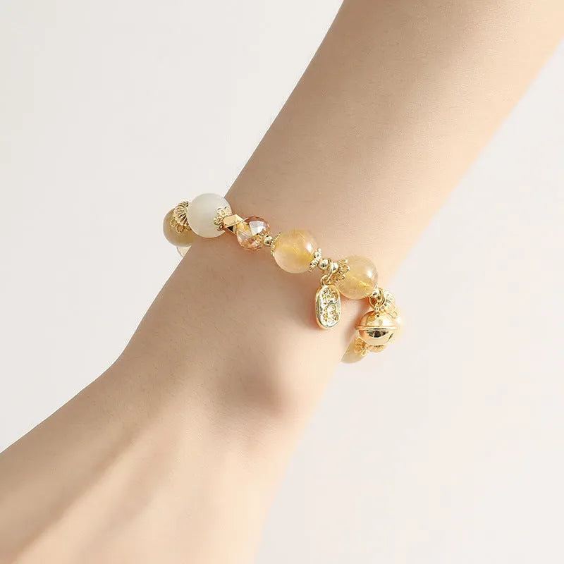 Gold electroplated bracelet with rutilated quartz and a ringing bell charm