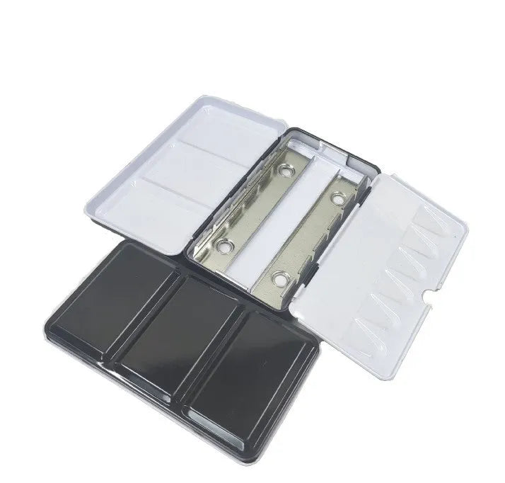 Tinplate metal folding watercolour paint box with colourful printed design, shown open to reveal compartments for solid paint pans.