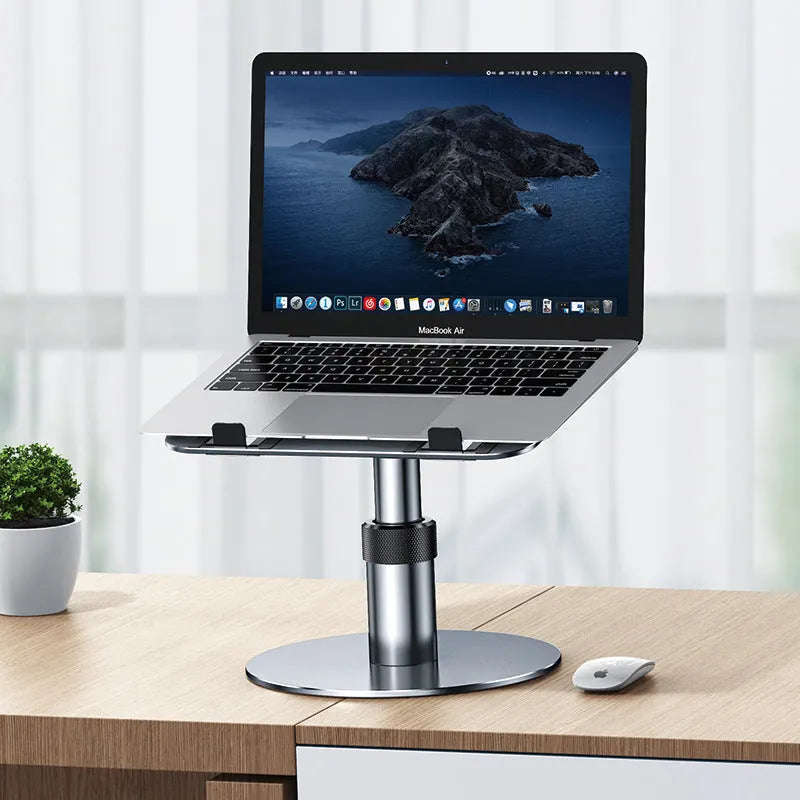 Silver aluminium adjustable laptop stand with rotating base and non-slip pads on a desk.
