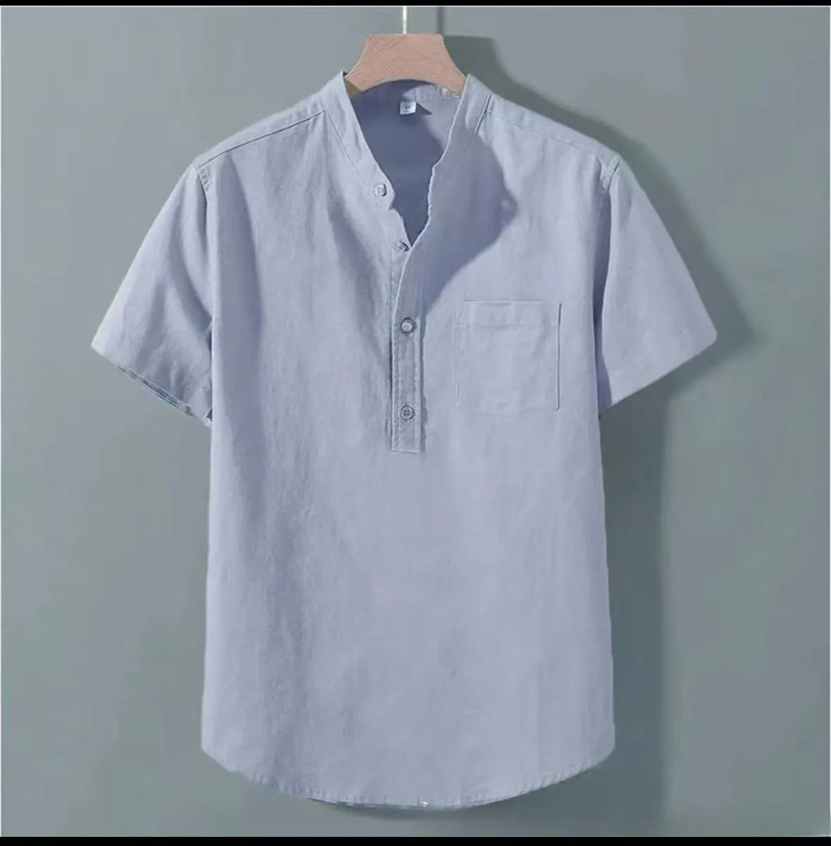 Man wearing a beige loose-fit linen casual shirt with a stand collar and short sleeves.