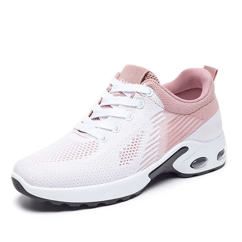 Women's pink flyknit running shoes with lace-up front, mesh lining, and flat PVC sole on a striped background.