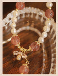 Women's hand-made strawberry quartz crystal bracelet with stringed pearls and bow detail